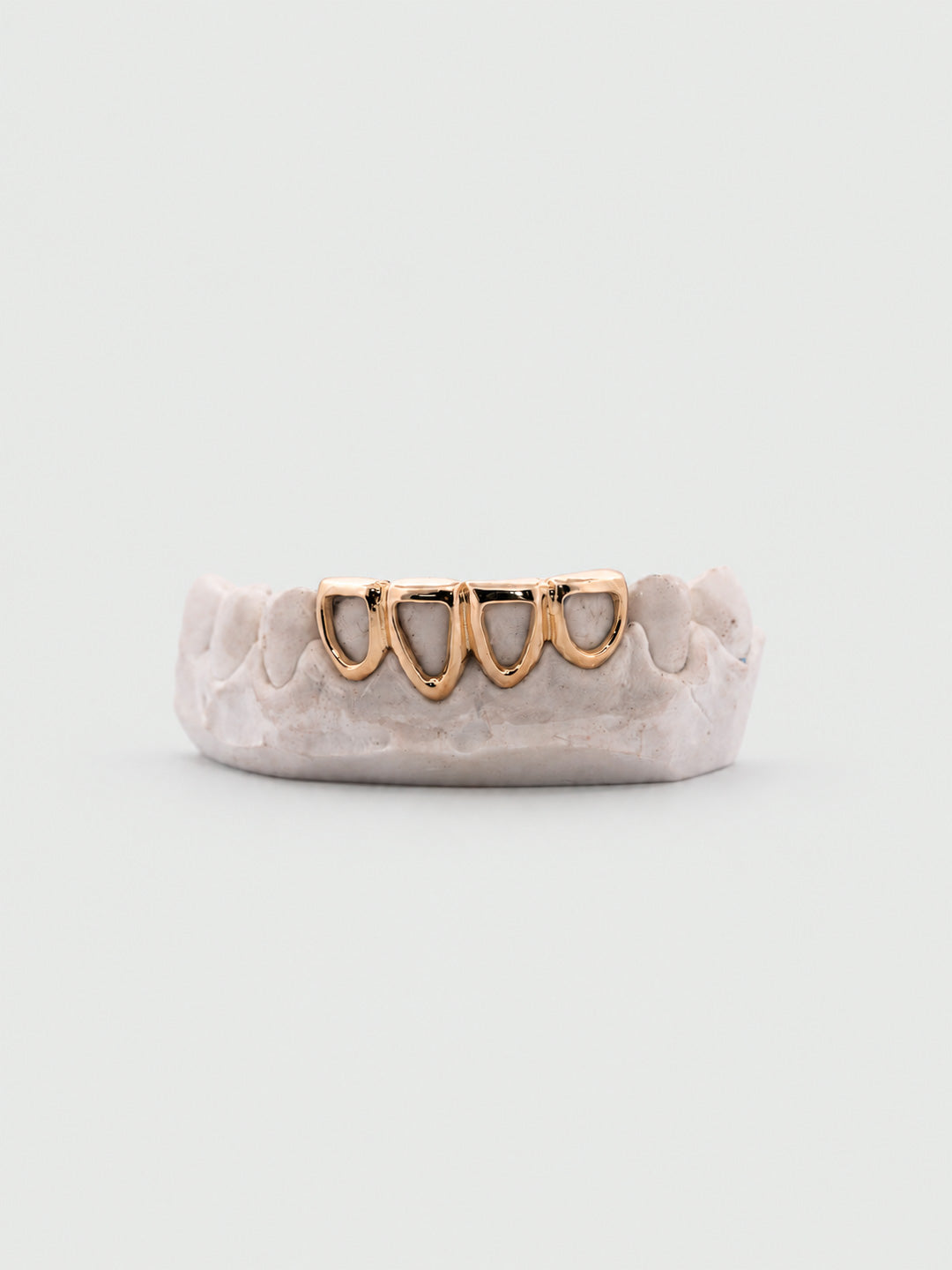 Bottom four window grillz in 18k yellow gold with open face cut-out windows on dental mould