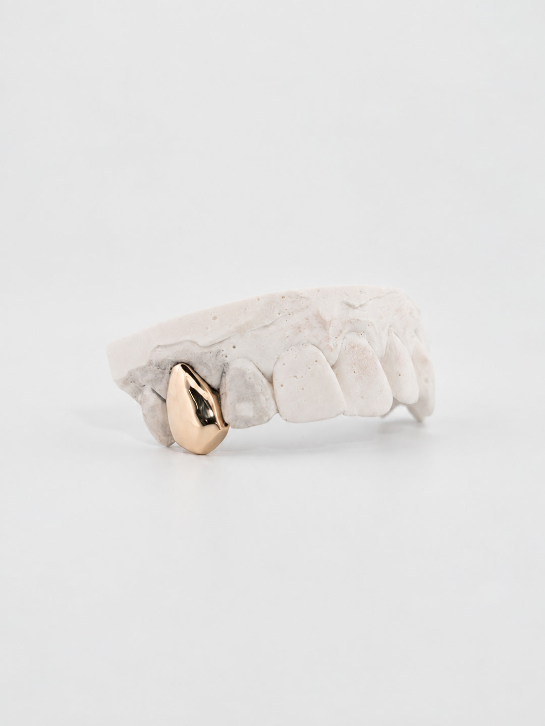 Single tooth grillz in 18k yellow gold, high polish gold cap on dental mould