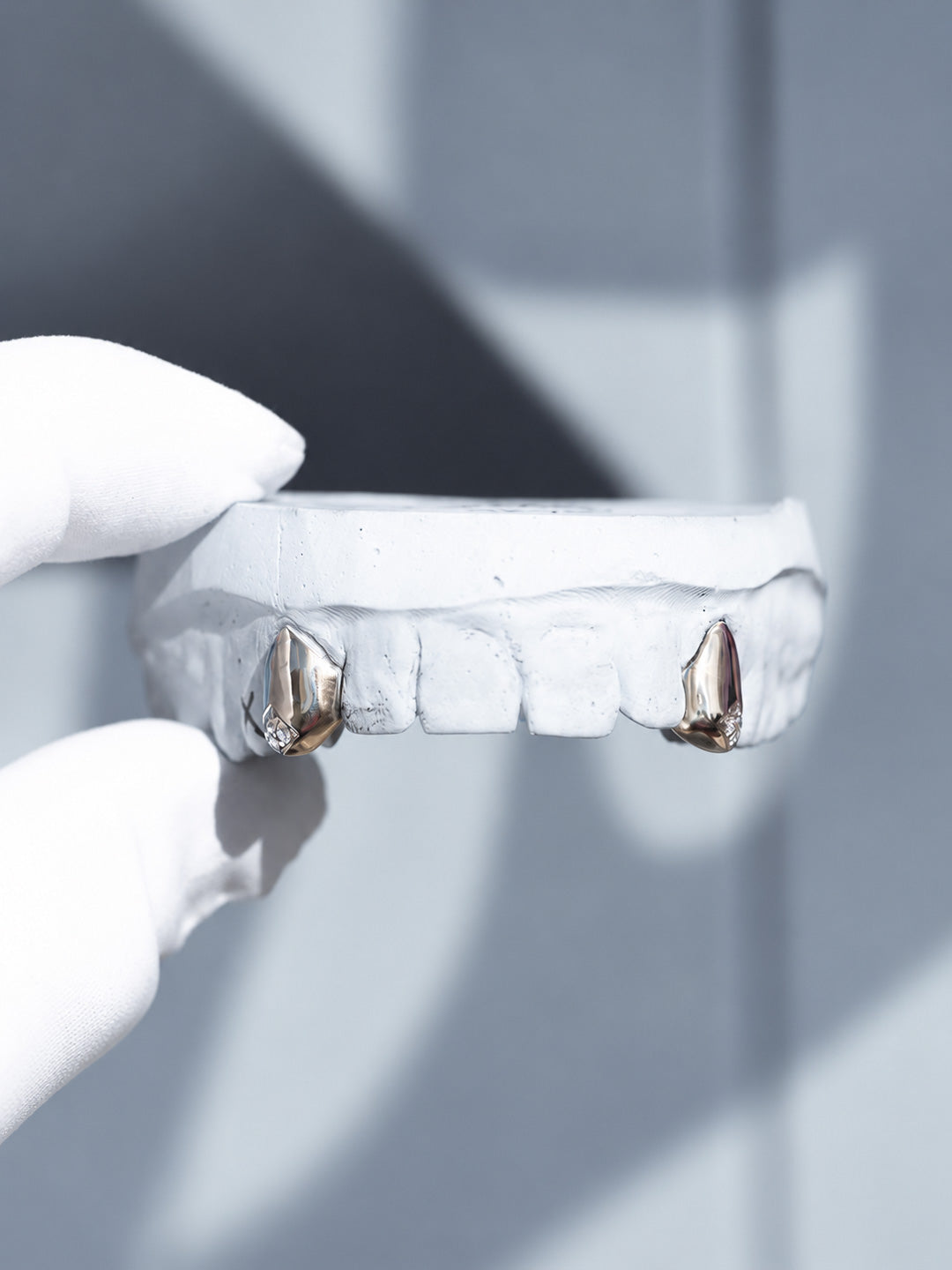 Two tooth diamond tip grillz in 18k white gold, cluster set diamond tips, front view