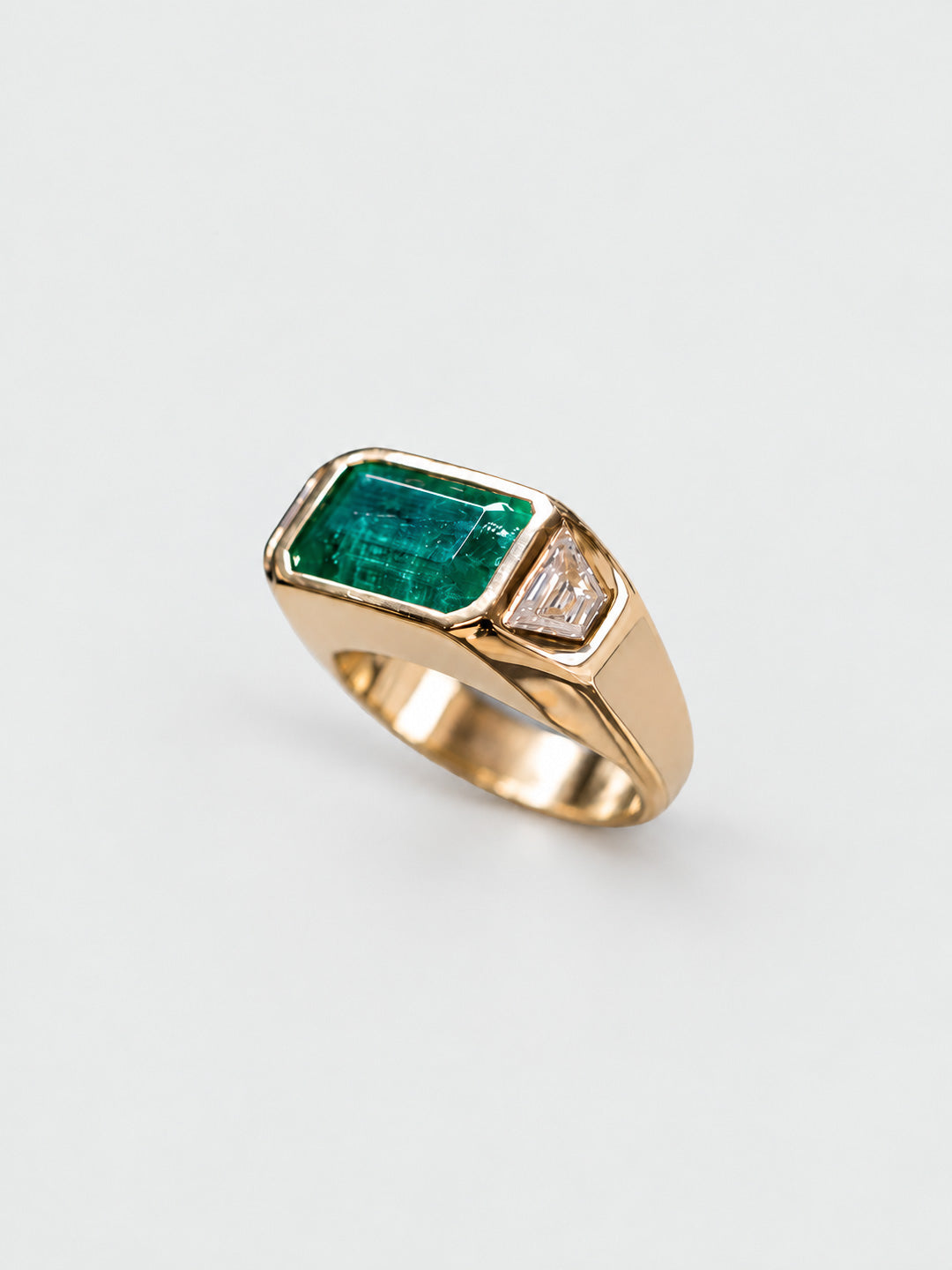 Custom engagement ring in gold with emerald cut emerald centre and diamond side stone, bespoke by Illoom Sydney