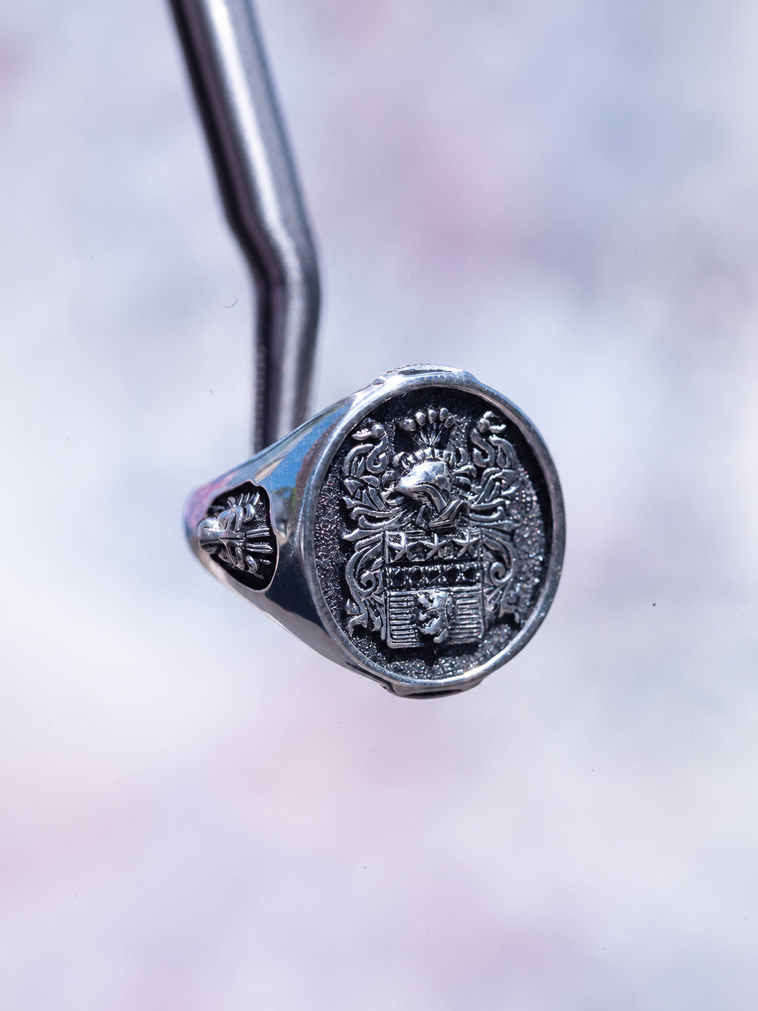 Side profile of hand-engraved silver family crest signet ring with lion shoulder detail and black diamond, by Illoom Sydney