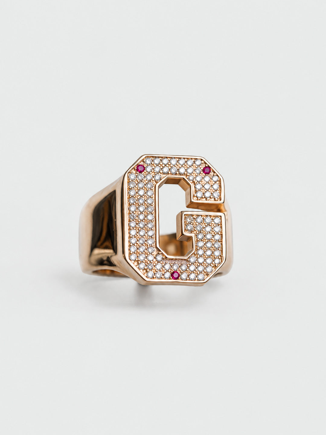 Custom letter-shaped initial ring in yellow gold with pavé diamond letter G and ruby accents, by Illoom Sydney