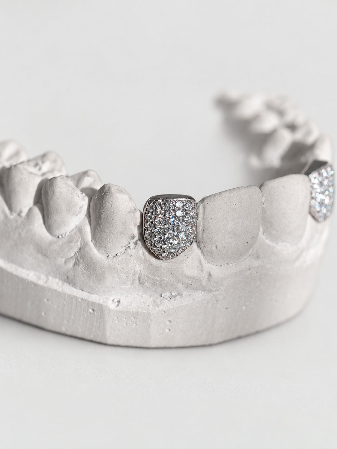 Single tooth grillz in sterling silver, pavé set with natural diamonds, side profile view